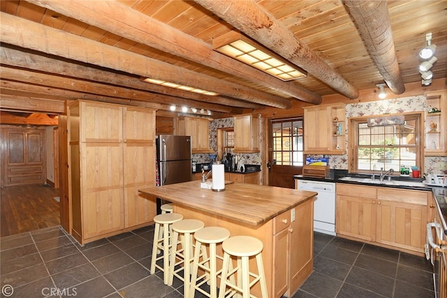 kitchen featuring dishwasher, a center island, backsplash, sink, and beamed ceiling