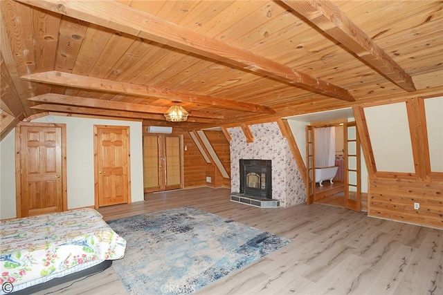 interior space featuring beam ceiling, a wood stove, wood ceiling, and hardwood / wood-style flooring