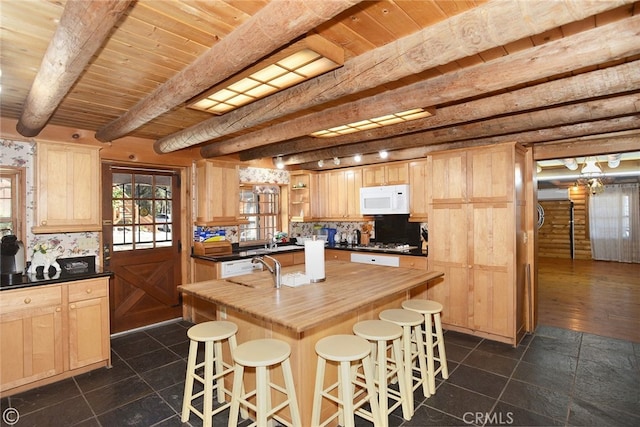 kitchen featuring beam ceiling and light brown cabinetry