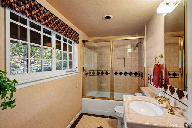 full bathroom with toilet, enclosed tub / shower combo, tile patterned floors, a textured ceiling, and vanity