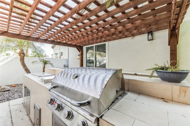 view of patio with an outdoor kitchen, a grill, a pergola, and fence