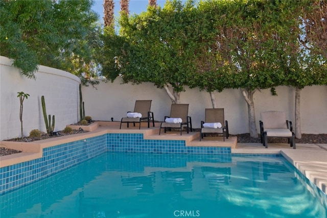 view of swimming pool featuring a patio area, a fenced in pool, and a fenced backyard