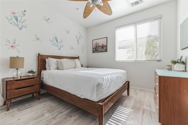 bedroom with visible vents, baseboards, light wood-style floors, and a ceiling fan