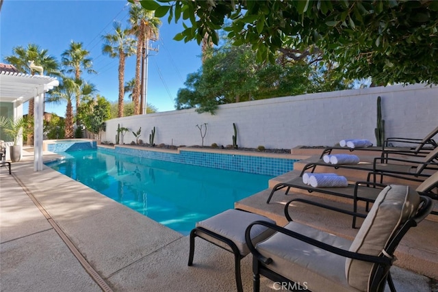 view of pool featuring a pool with connected hot tub, a fenced backyard, a pergola, and a patio area