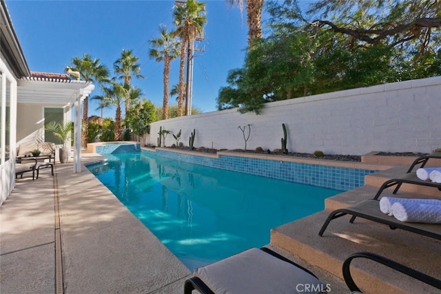 view of pool featuring a pool with connected hot tub, a fenced backyard, a pergola, and a patio area