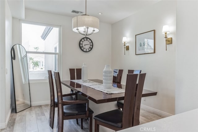 dining area featuring wood finished floors, visible vents, and baseboards