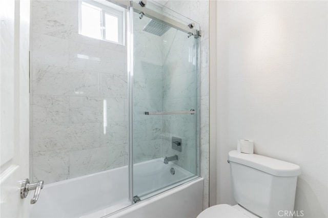 bathroom with toilet and bath / shower combo with glass door