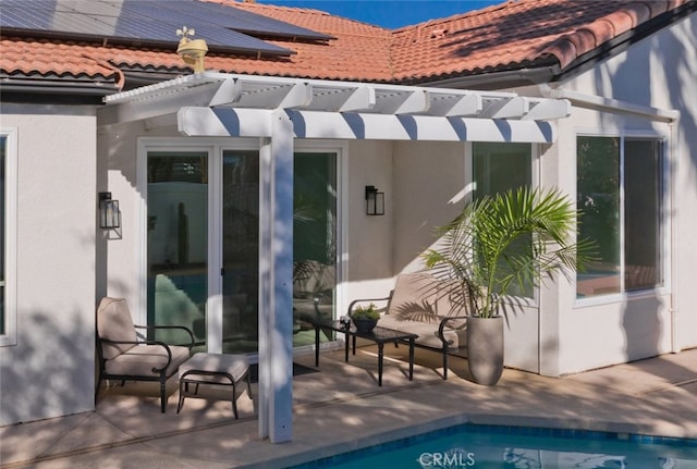 rear view of property featuring a tiled roof, a patio area, an outdoor pool, and stucco siding