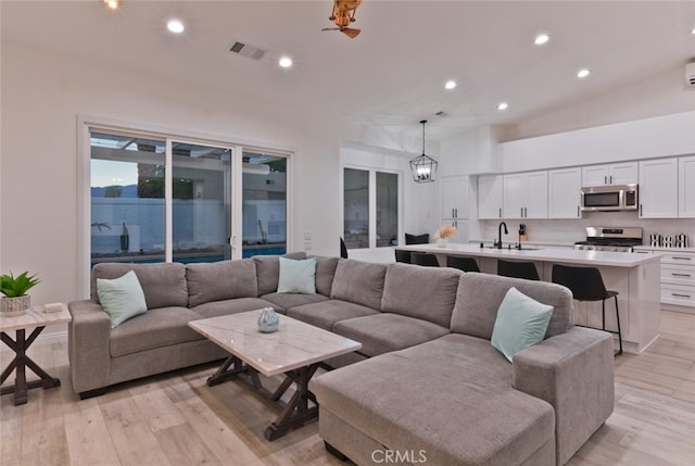 living room featuring recessed lighting, visible vents, light wood finished floors, and a chandelier