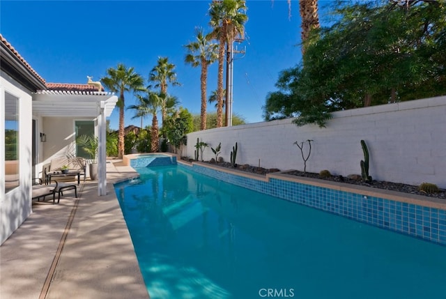 view of swimming pool featuring a patio area, a pool with connected hot tub, a fenced backyard, and a pergola