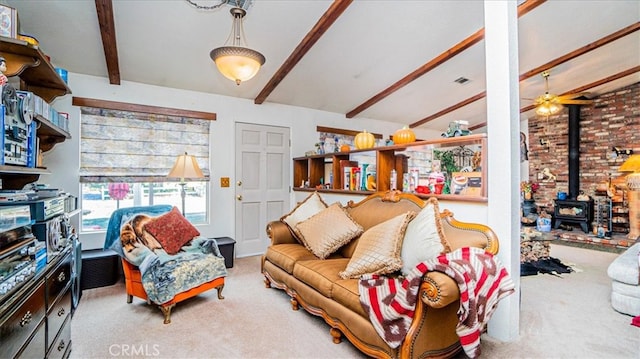 living room with carpet, vaulted ceiling with beams, a wood stove, and ceiling fan