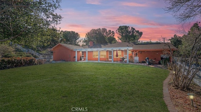 view of front of property with a patio area and a lawn