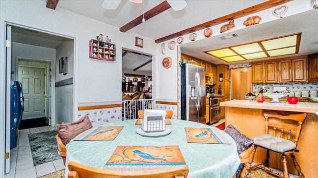 tiled dining area with beamed ceiling and ceiling fan