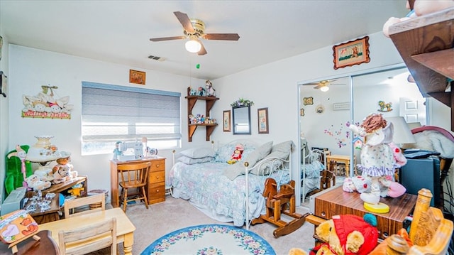 bedroom with light carpet, ceiling fan, and a closet