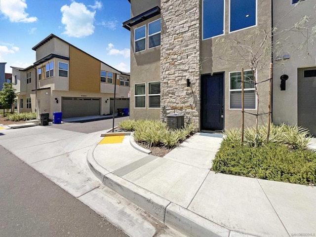 exterior space with a garage and central air condition unit