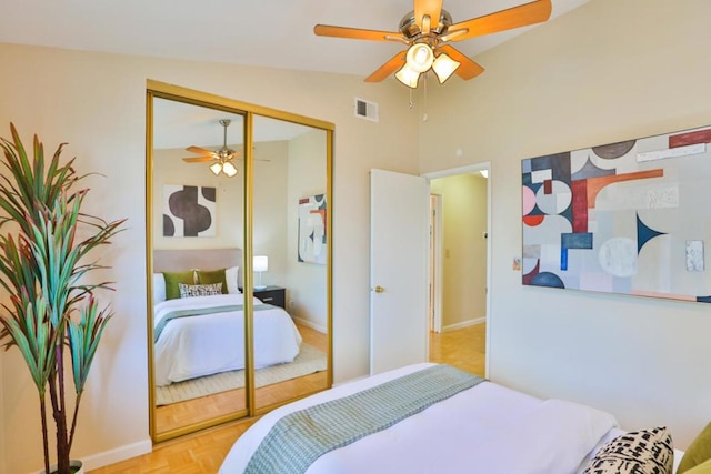 bedroom with ceiling fan, light parquet floors, a closet, and lofted ceiling