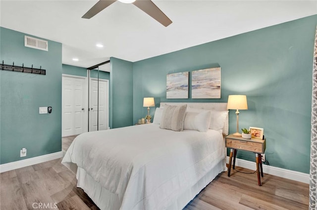 bedroom featuring light wood-type flooring, ceiling fan, and a closet