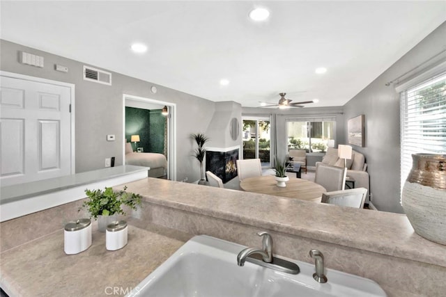 living room with sink, plenty of natural light, and ceiling fan