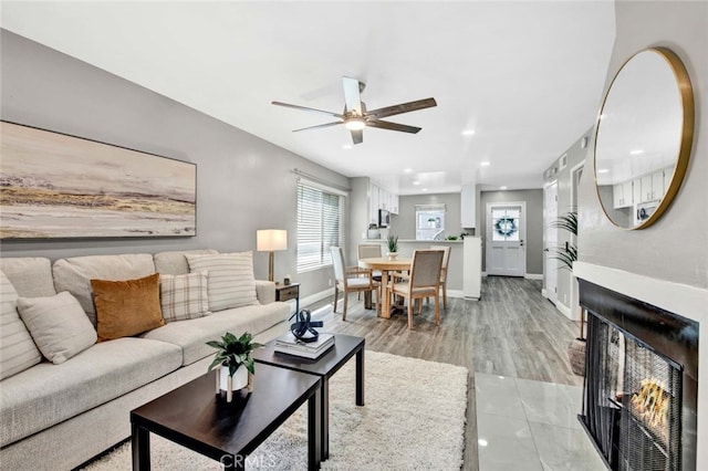 living room featuring ceiling fan and light hardwood / wood-style floors