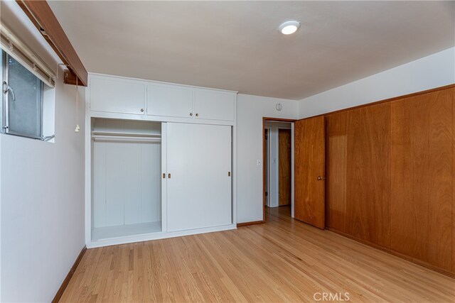 unfurnished bedroom with light hardwood / wood-style flooring and a closet