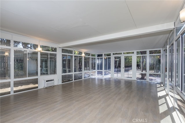 unfurnished sunroom with a wall unit AC, plenty of natural light, and french doors