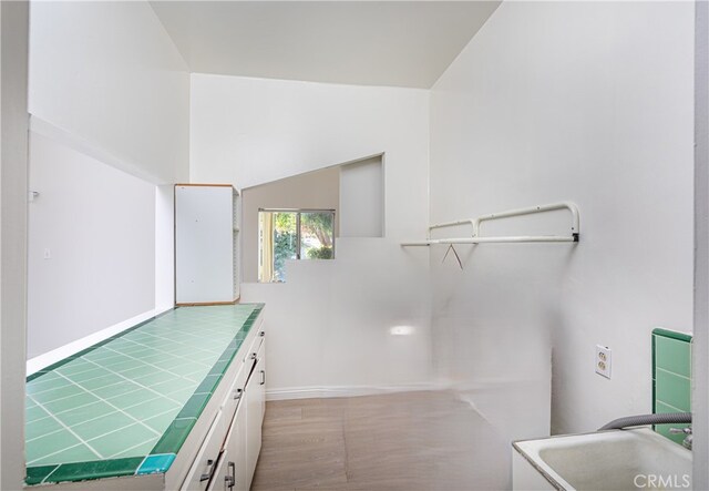 washroom with cabinets, light hardwood / wood-style flooring, and hookup for a washing machine