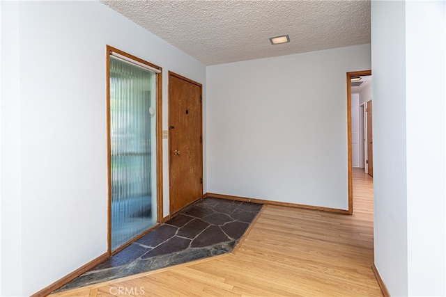 hallway with hardwood / wood-style flooring and a textured ceiling