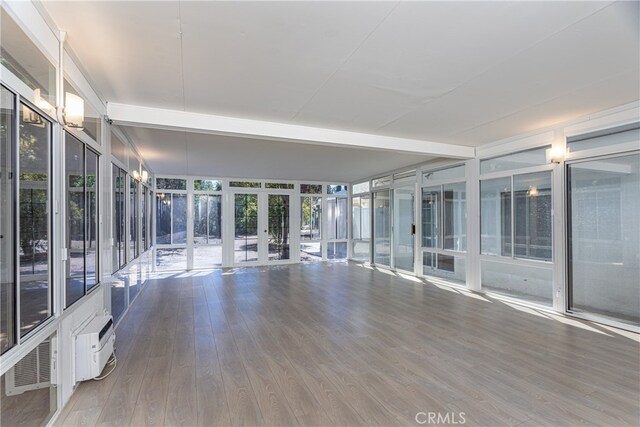 unfurnished sunroom with a wall unit AC and french doors