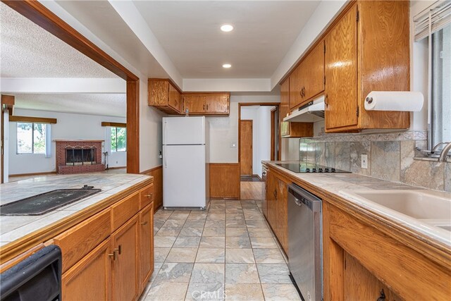 kitchen with black electric stovetop, dishwasher, white refrigerator, tile countertops, and black stovetop