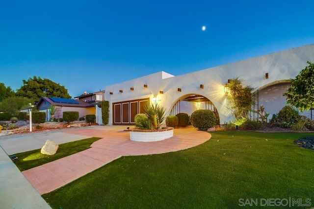 view of front of house with a front yard and solar panels