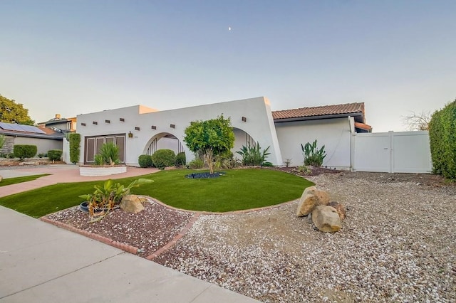 view of front facade with a front lawn and solar panels