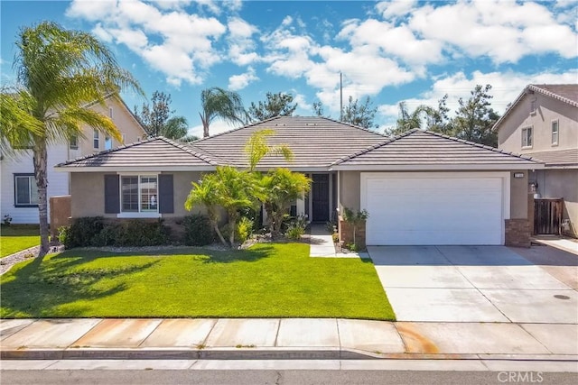 single story home featuring driveway, a garage, a tile roof, a front yard, and stucco siding