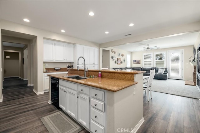 kitchen featuring open floor plan, a sink, white cabinetry, and recessed lighting