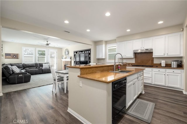 kitchen with black dishwasher, visible vents, dark wood-type flooring, a sink, and under cabinet range hood