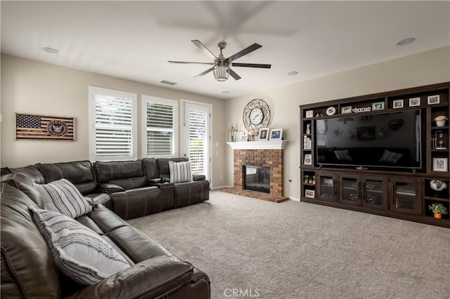 living room featuring carpet, a brick fireplace, visible vents, and ceiling fan