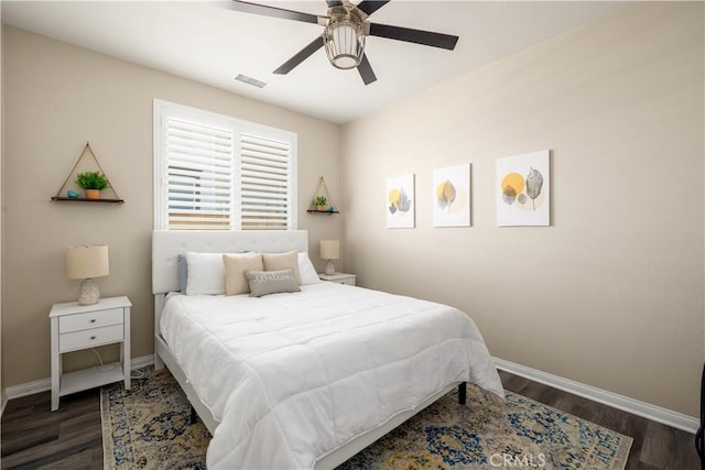 bedroom featuring visible vents, ceiling fan, baseboards, and wood finished floors