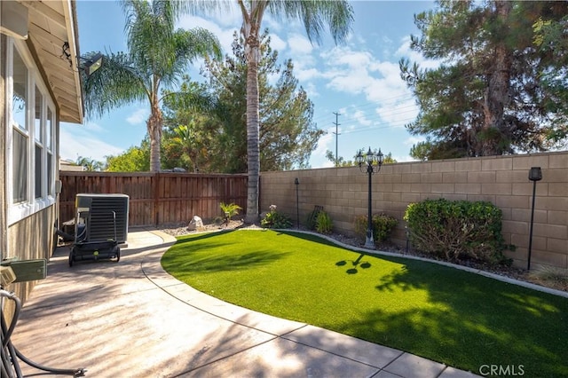 view of yard featuring a patio area, a fenced backyard, and central AC