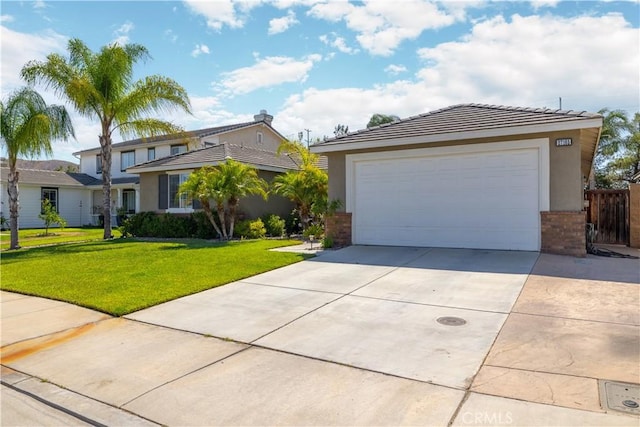 view of front facade with a garage, stucco siding, brick siding, and a front yard