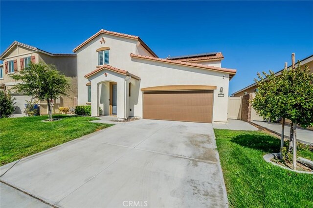 mediterranean / spanish house with a front yard and a garage