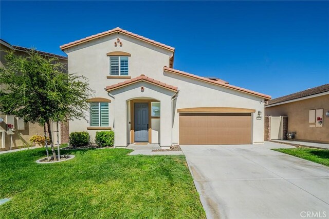 mediterranean / spanish-style home featuring a garage and a front lawn