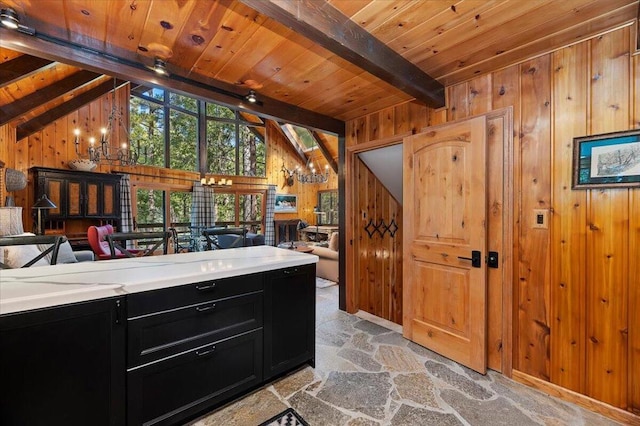 kitchen with wood walls, lofted ceiling with beams, light tile patterned floors, and wooden ceiling