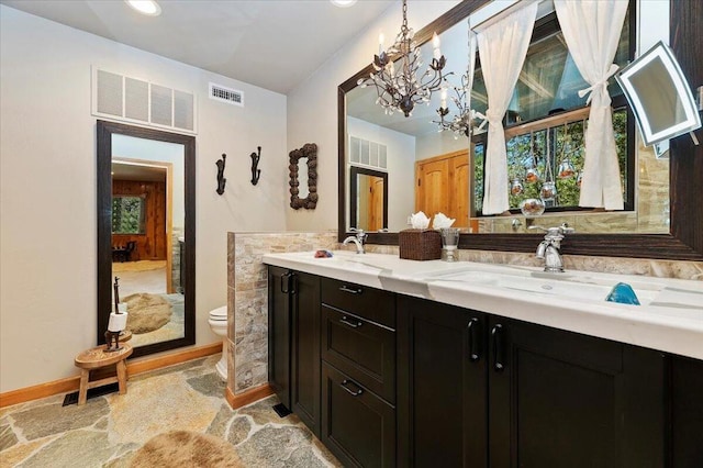 bathroom featuring a notable chandelier, tile patterned floors, dual vanity, and toilet