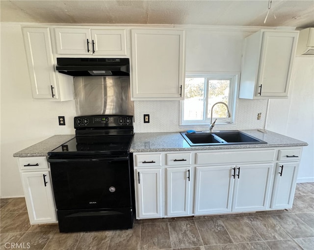 kitchen with sink, electric range, light stone counters, and white cabinetry