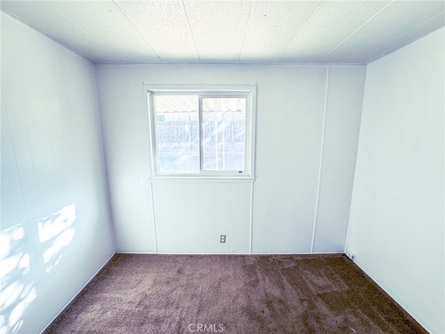 carpeted empty room with a textured ceiling