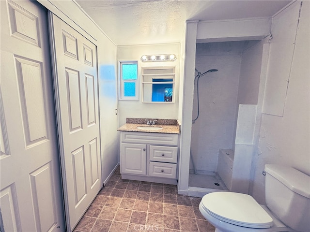 bathroom with vanity, toilet, and a shower