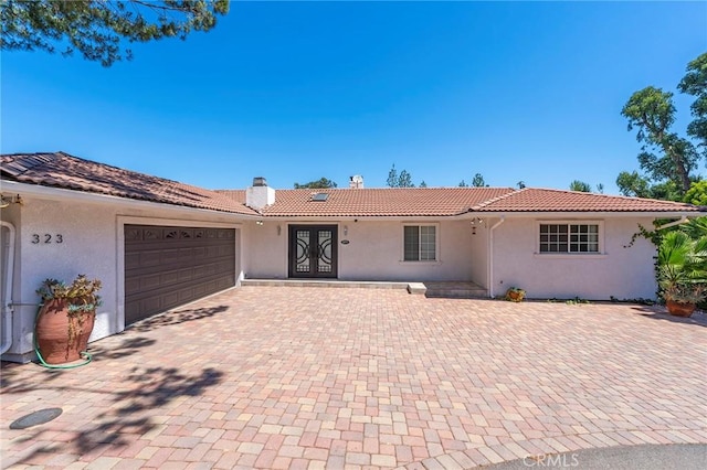 ranch-style house with french doors and a garage