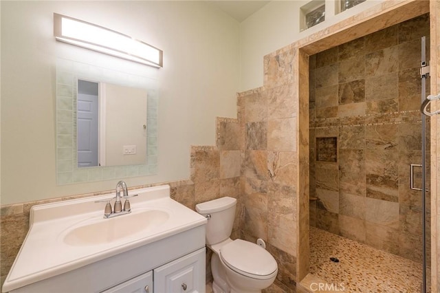 bathroom featuring vanity, toilet, and a shower with door