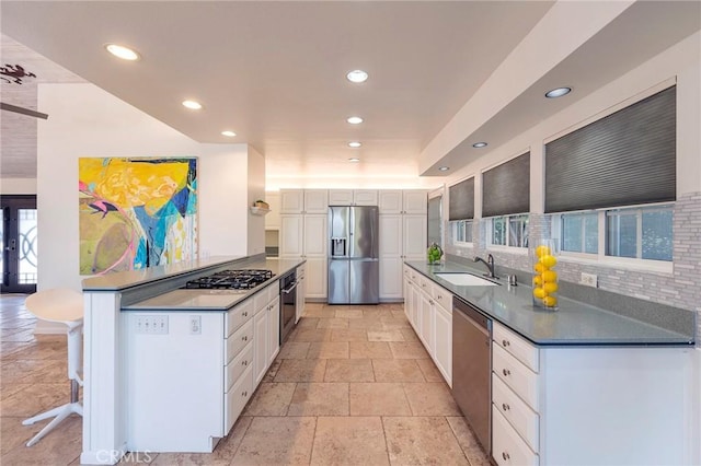 kitchen featuring stainless steel appliances, white cabinetry, a healthy amount of sunlight, and sink