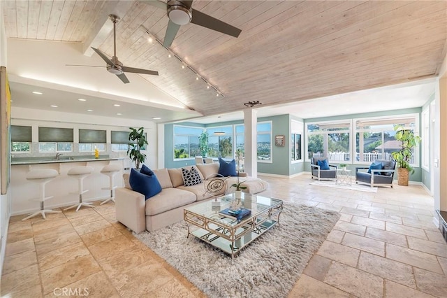 living room featuring ceiling fan, plenty of natural light, rail lighting, and lofted ceiling