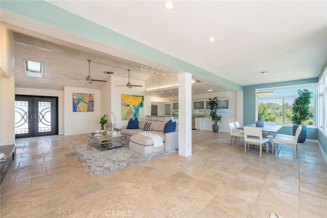 living room featuring french doors, vaulted ceiling with beams, and ceiling fan